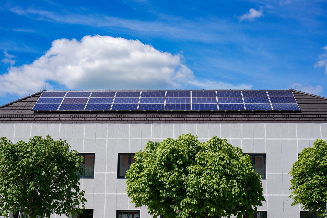 Crafting Captivating Headlines: Your awesome post title goes here Energy-efficient building topped with solar panels and surrounded by lush trees.